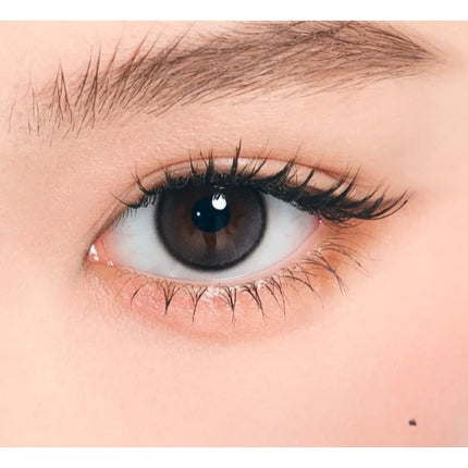 Model wearing OLENS Glowy Tear Charcoal monthly colored contacts for cool luminous watery eyes NewJeans pick