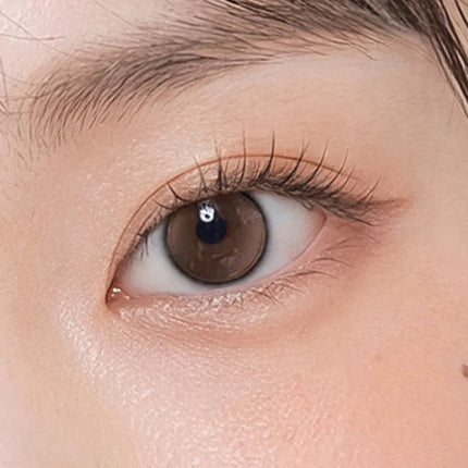 Model wearing OLENS Glowy Tear Mini Brown monthly colored contacts for small diameter dewy eyes NewJeans pick